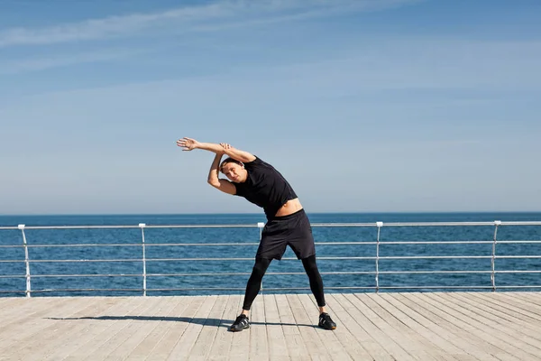 Uomo flessione durante l'allenamento sul molo — Foto Stock