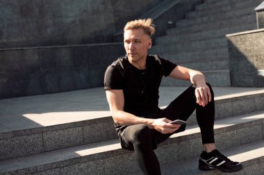 Merdivenlerde oturan kendine güvenen adam