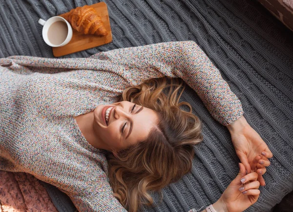 Glad kvinna på sängen — Stockfoto