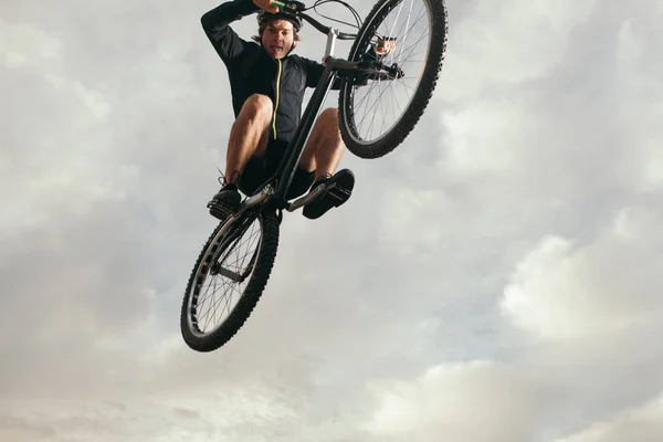 Hombre realizando salto en bicicleta — Foto de Stock