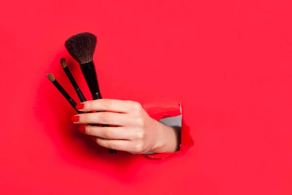 Cosecha mano femenina con cepillos cosméticos —  Fotos de Stock