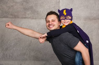 Adam süper kahraman gibi poz çocukla