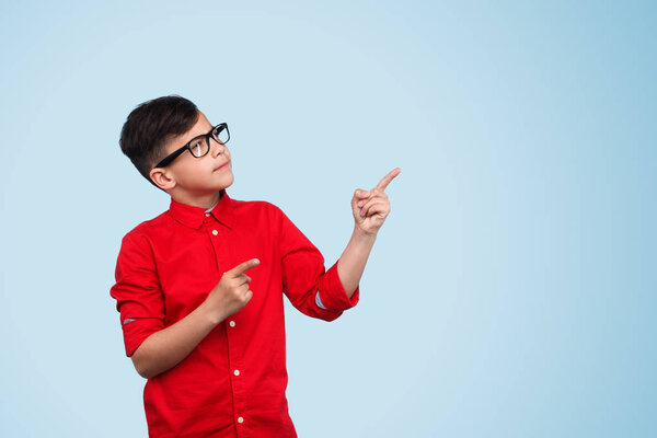Kid gesturing up on blue background