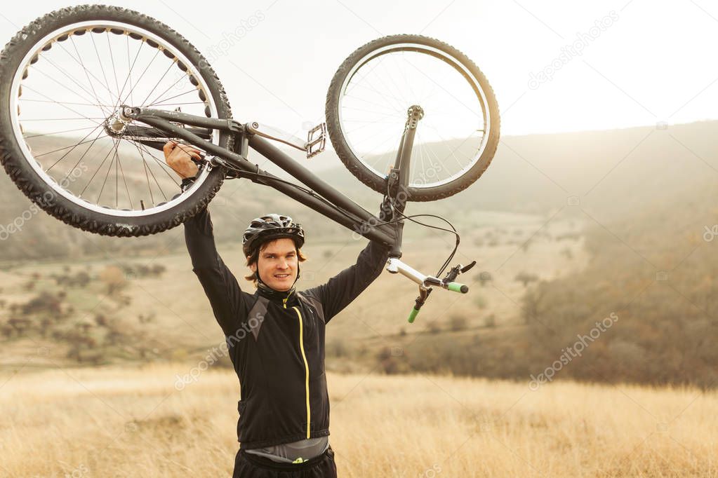 Young man holding bike up