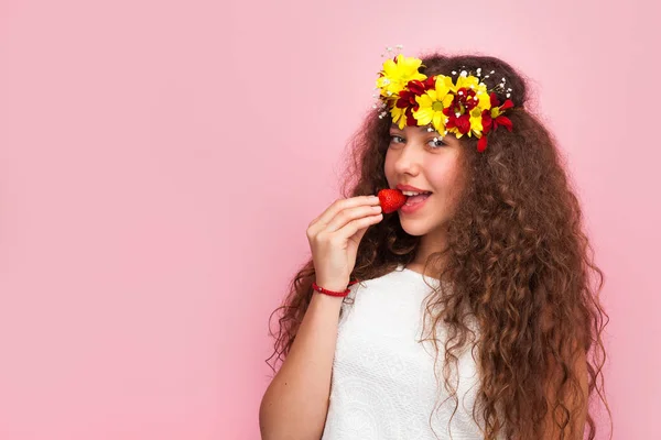 Krullend vrouw bijten aardbei — Stockfoto