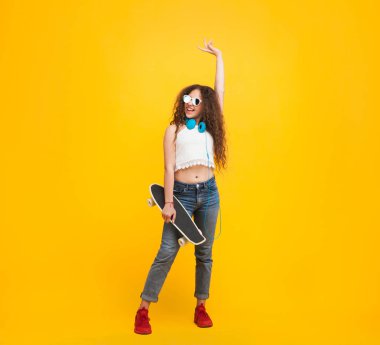 Genç bir kadın kaykayla poz veriyor.