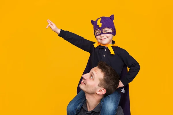 Man håller ungen i superhjälte kostym — Stockfoto