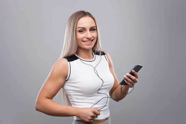 Jovem mulher muscular com smartphone — Fotografia de Stock