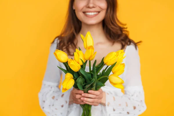 Niña sosteniendo tulipanes amarillos — Foto de Stock