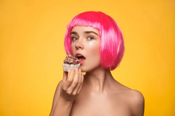 Девушка в парике ест кексы — стоковое фото