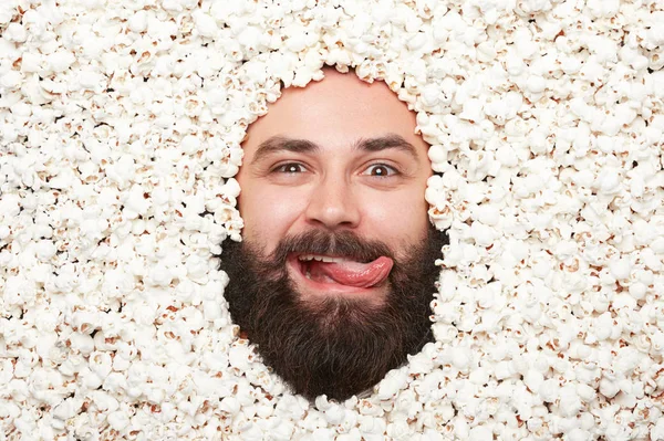 Uomo barbuto sdraiato nei popcorn — Foto Stock
