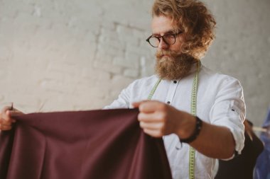 kumaş parçası tutan gözlüklü adam 