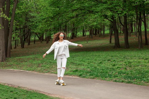 ผู้หญิงขี่สเก็ตบอร์ดในสวนสาธารณะ . — ภาพถ่ายสต็อก