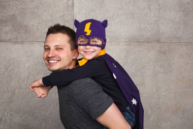 Çocuk süper kahraman kostümü içinde tutan adam