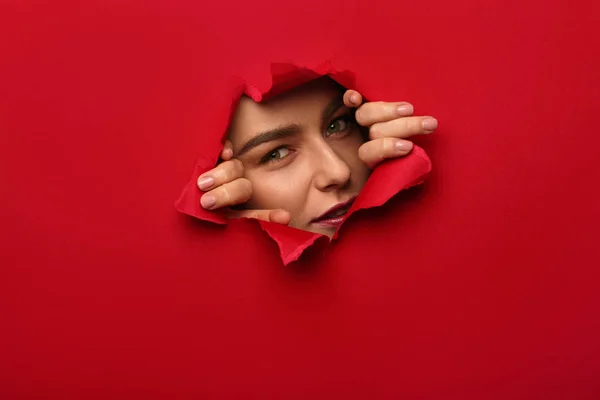 Young woman tearing red paper — Stock Photo, Image