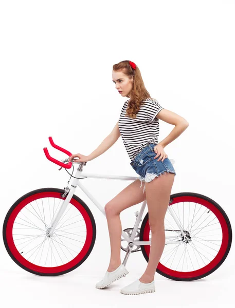 Серьезная молодая женщина с велосипедом на белом — стоковое фото