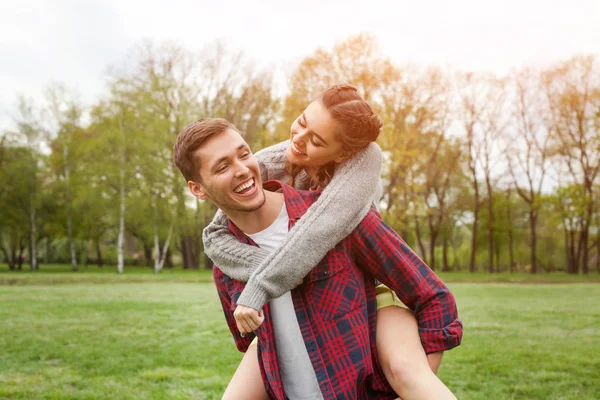Man carrying laughing girl on back — Stock Photo, Image