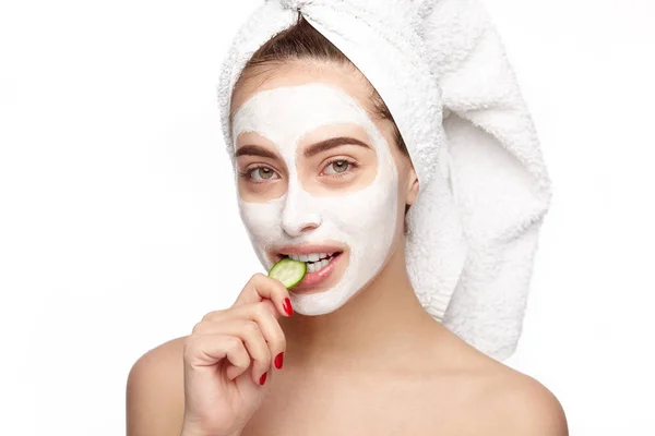 Mujer en cosméticos mordiendo un pepino — Foto de Stock