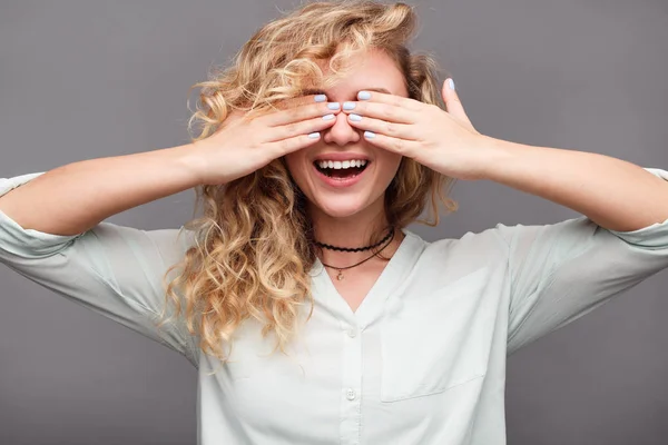 Sonriente chica cubriendo los ojos con las manos — Foto de Stock