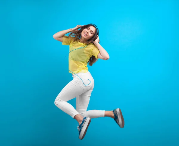 Adolescente chica en los auriculares saltando —  Fotos de Stock