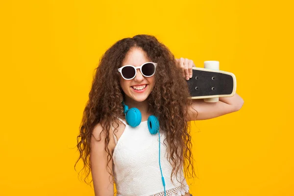 Curly menina de cabelos em óculos de sol usando fones de ouvido — Fotografia de Stock