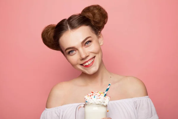 Девушка с булочками держит стакан молочного коктейля — стоковое фото