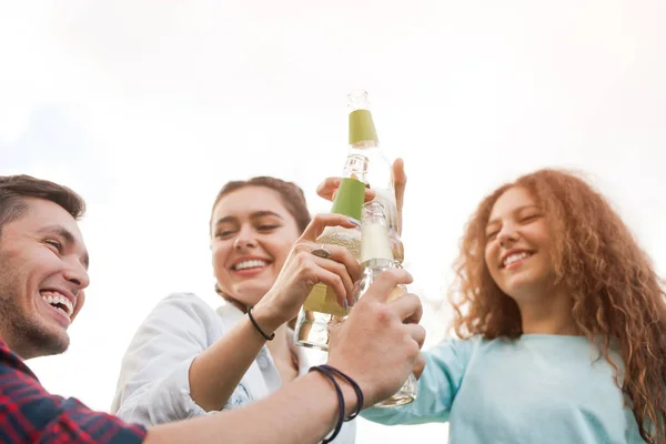 Friends clinking with bottles — Stock Photo, Image