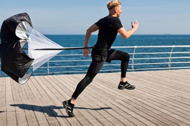 Eğitim paraşüt ile iskelede koşan adam