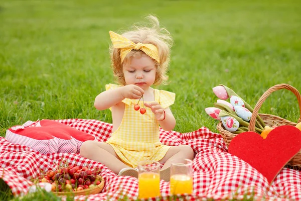 Junges Mädchen mit Kirschen auf Decke — Stockfoto