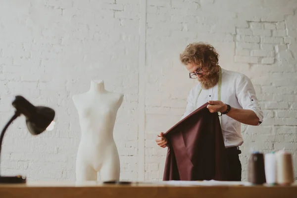 Tailor looking at piece of fabric — Stock Photo, Image