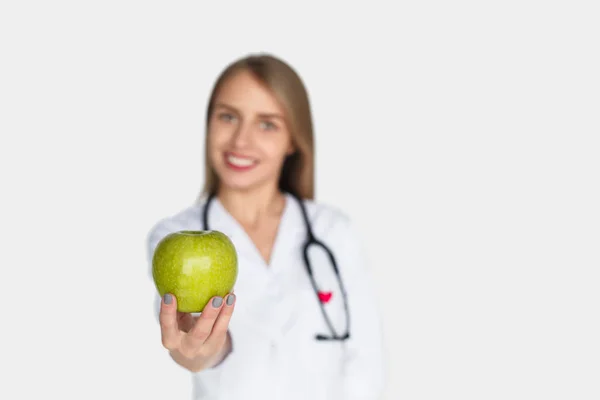 Läkare outstretching hand med apple — Stockfoto