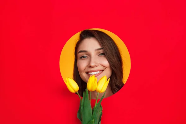 Chica sonriente con tulipanes posando en el estudio — Foto de Stock