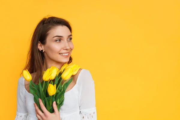 Молодая женщина с желтыми тюльпанами позирует — стоковое фото