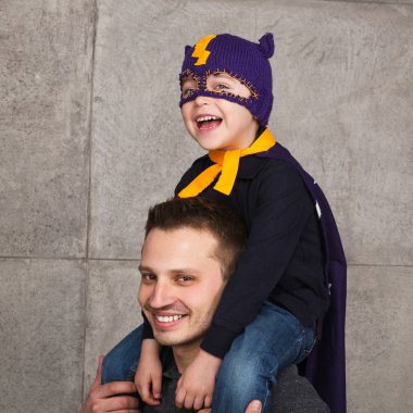 Çocuk kahraman kostümlü babalar omuzlarında