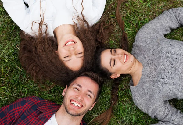 Junge Freunde liegen im Gras — Stockfoto