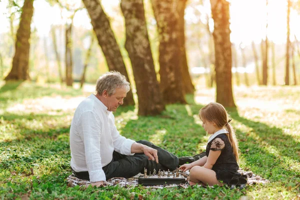 Dziadek z dziewczyna gra w szachy — Zdjęcie stockowe