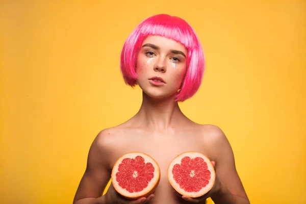 Model in wig posing with grapefruits — Stock Photo, Image
