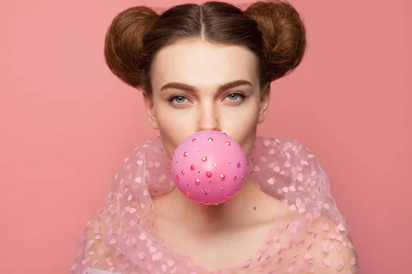 Woman blowing balloon looking at camera — Stock Photo, Image