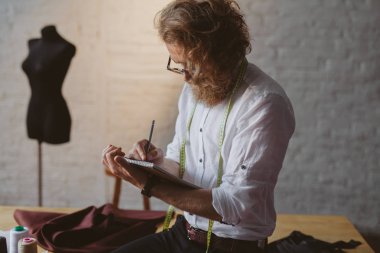 Adam masaya oturan yazma gözlük