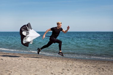 Kumsalda paraşüt ile çalışan adam