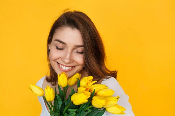 Brunett kvinna som håller blommor leende — Stockfoto