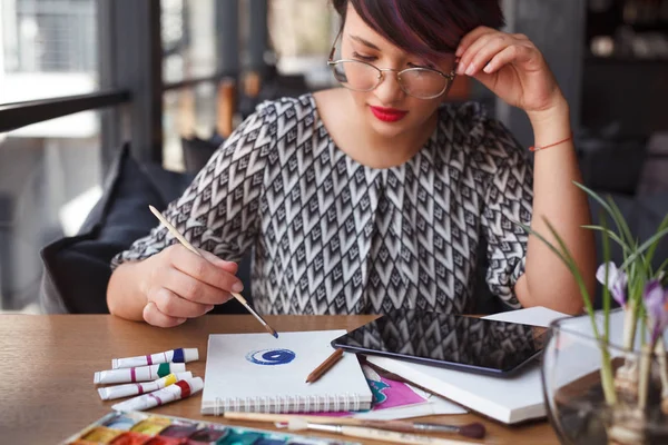 Ragazza pensierosa che disegna in notebook con vernici — Foto Stock