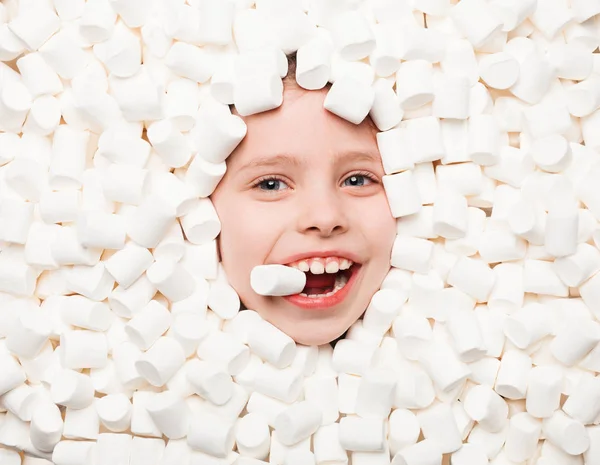 Glückliches Kind liegt in Marshmallows — Stockfoto