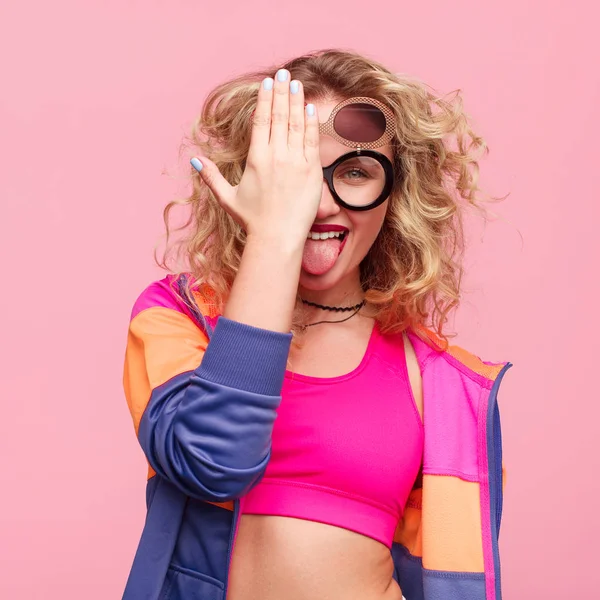 Hipster chica cubriendo ojo mostrando lengua — Foto de Stock