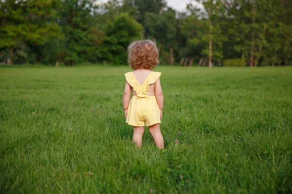 年轻的金发女孩，站在草地上 — 图库照片