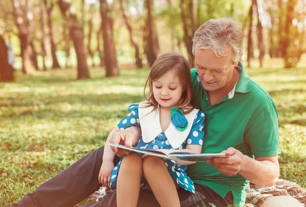 Dziadek z dziewczyną, czytanie książki — Zdjęcie stockowe
