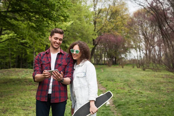 Vrienden in het park kijken telefoon — Stockfoto