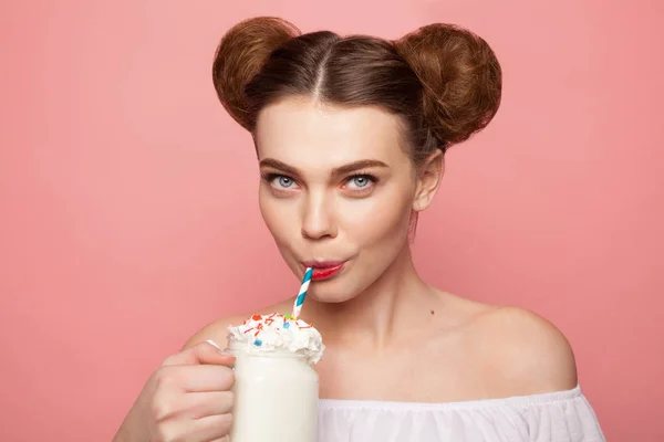 Красивая девушка пьет молочный коктейль с соломой — стоковое фото