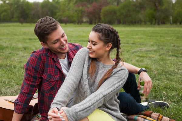 公園で毛布の上に座って笑顔のカップル. — ストック写真