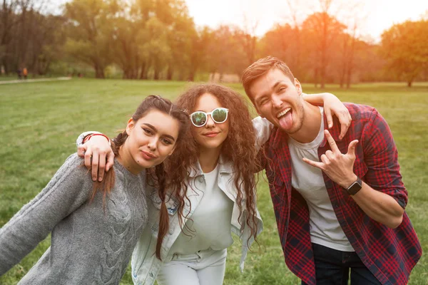 Drie jongere poseren in park — Stockfoto